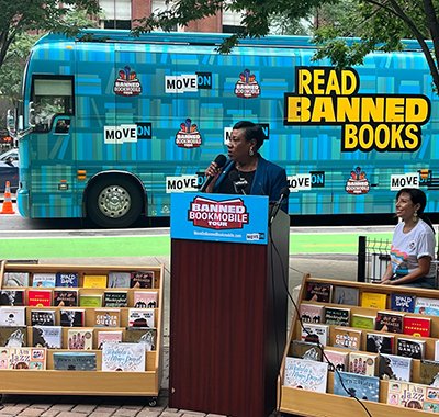 NEA President Becky Pringle behind a podium during banned bookmobile tour.